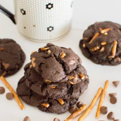 A stack of caramel pretzel cookies paired with a cup of coffee.