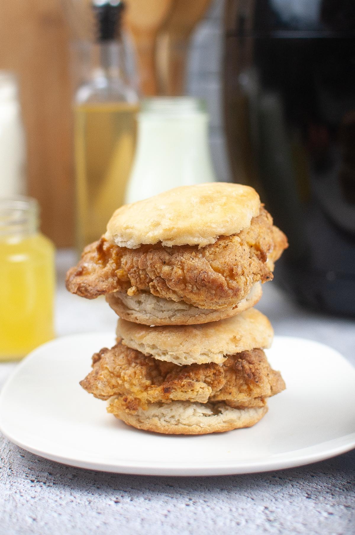 A plate with a stack of chicken biscuit sandwiches.