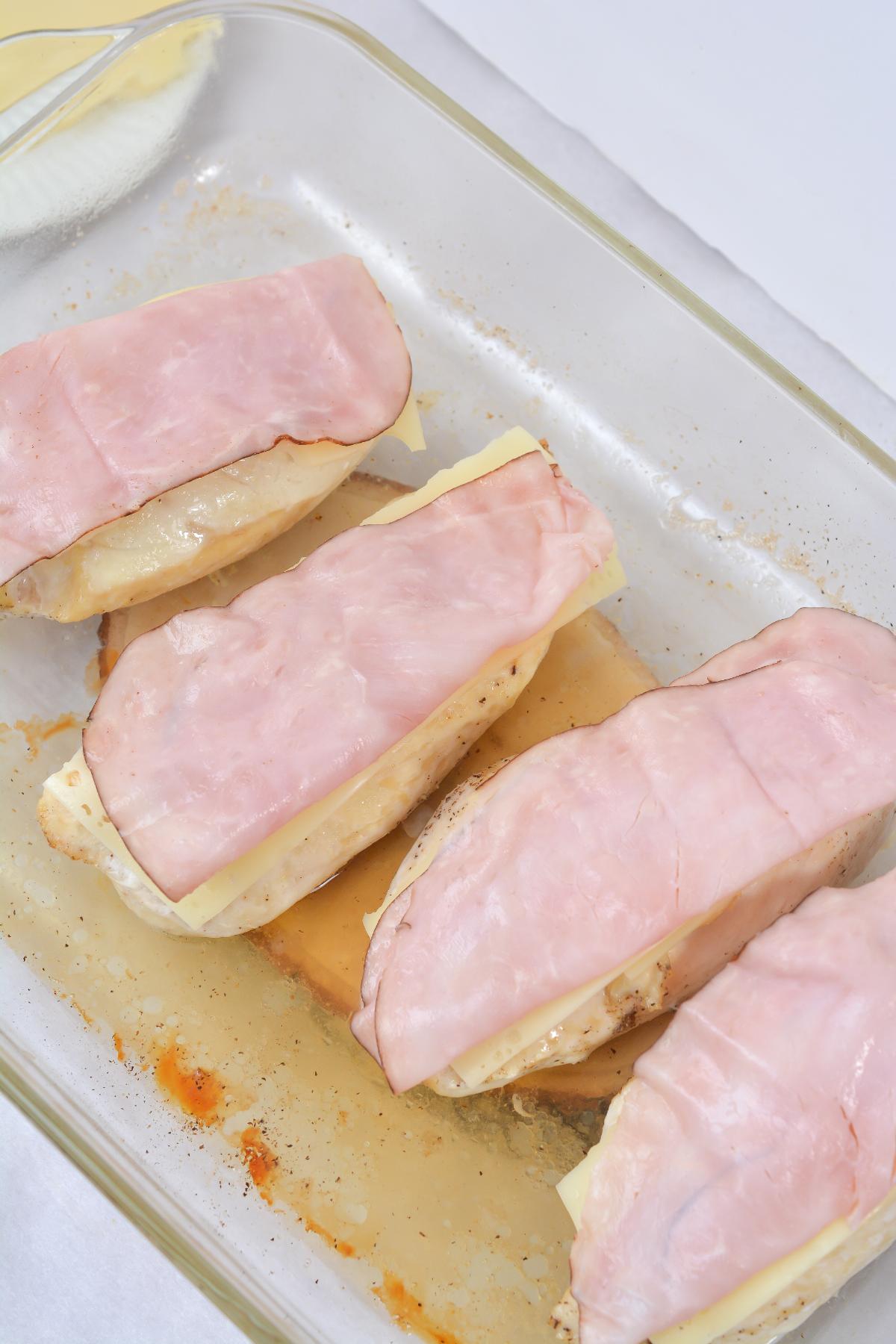 a Slice of Ham is added on top of the cheese and chicken breast.