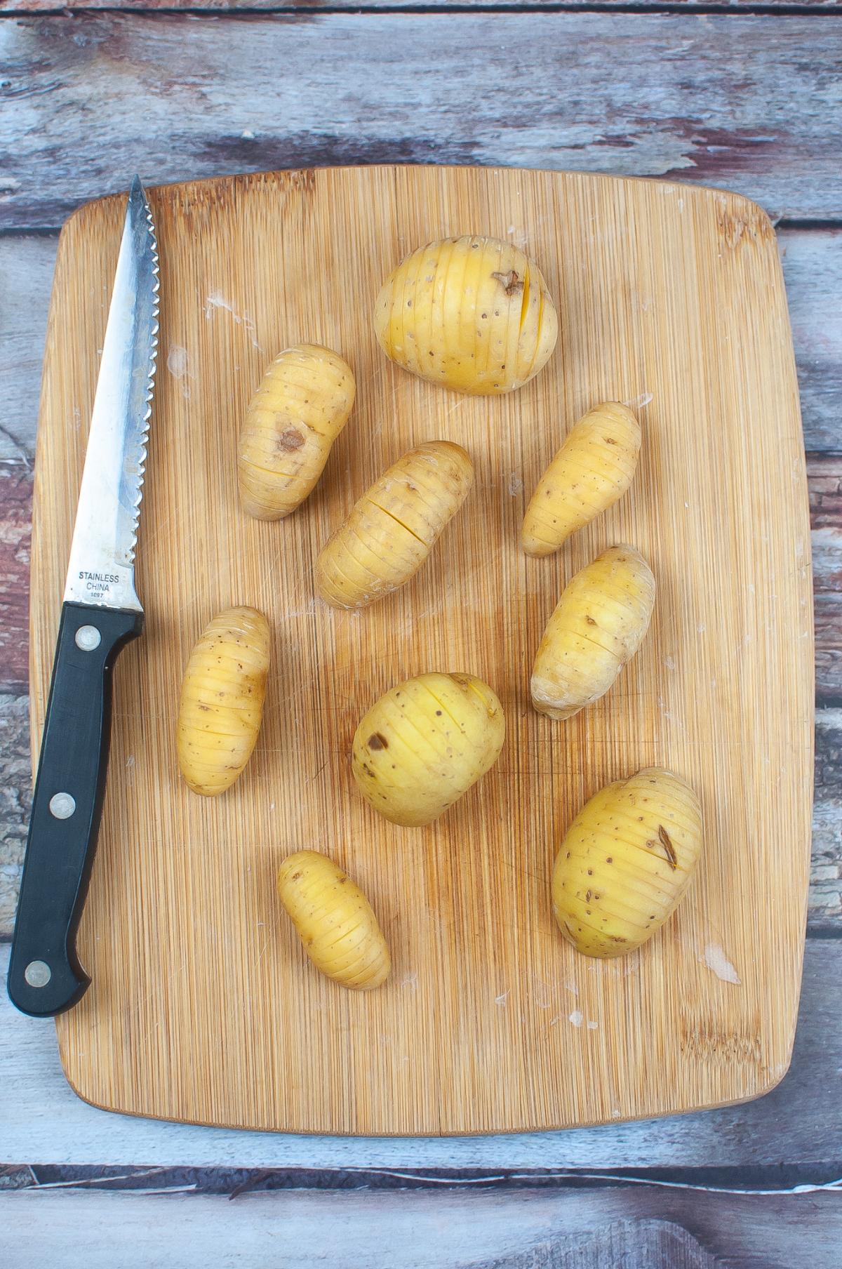 Potatoes on a cutting board with a knife.