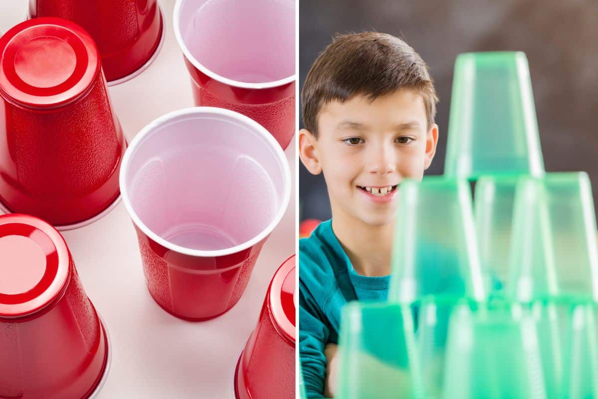 A teen boy is participating in a minute to win it game with a stack of red cups.