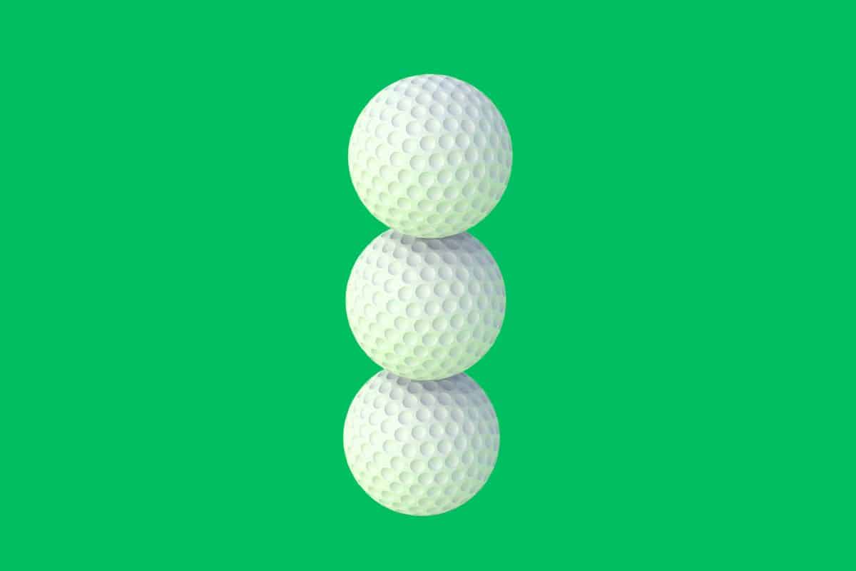 Three golf balls stacked on top of each other on a green background.