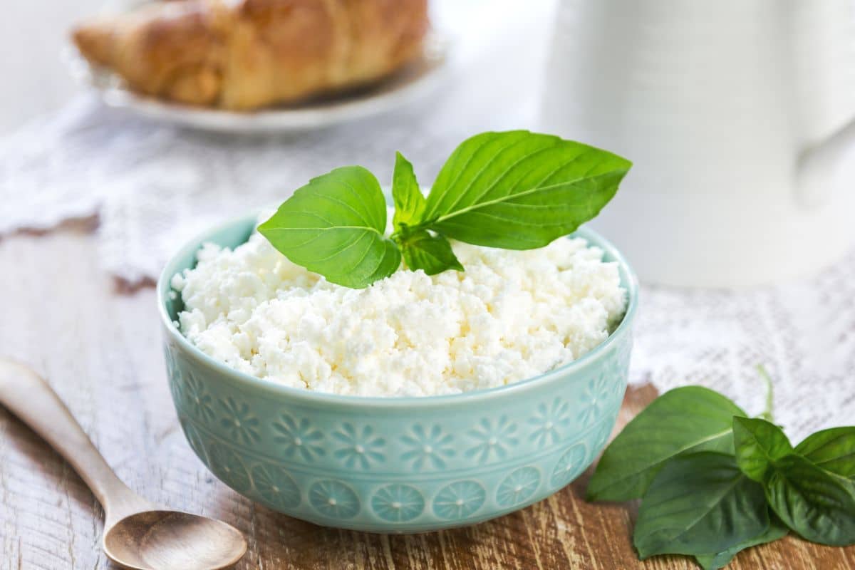 Ricotta cheese in a bowl on a wooden table.