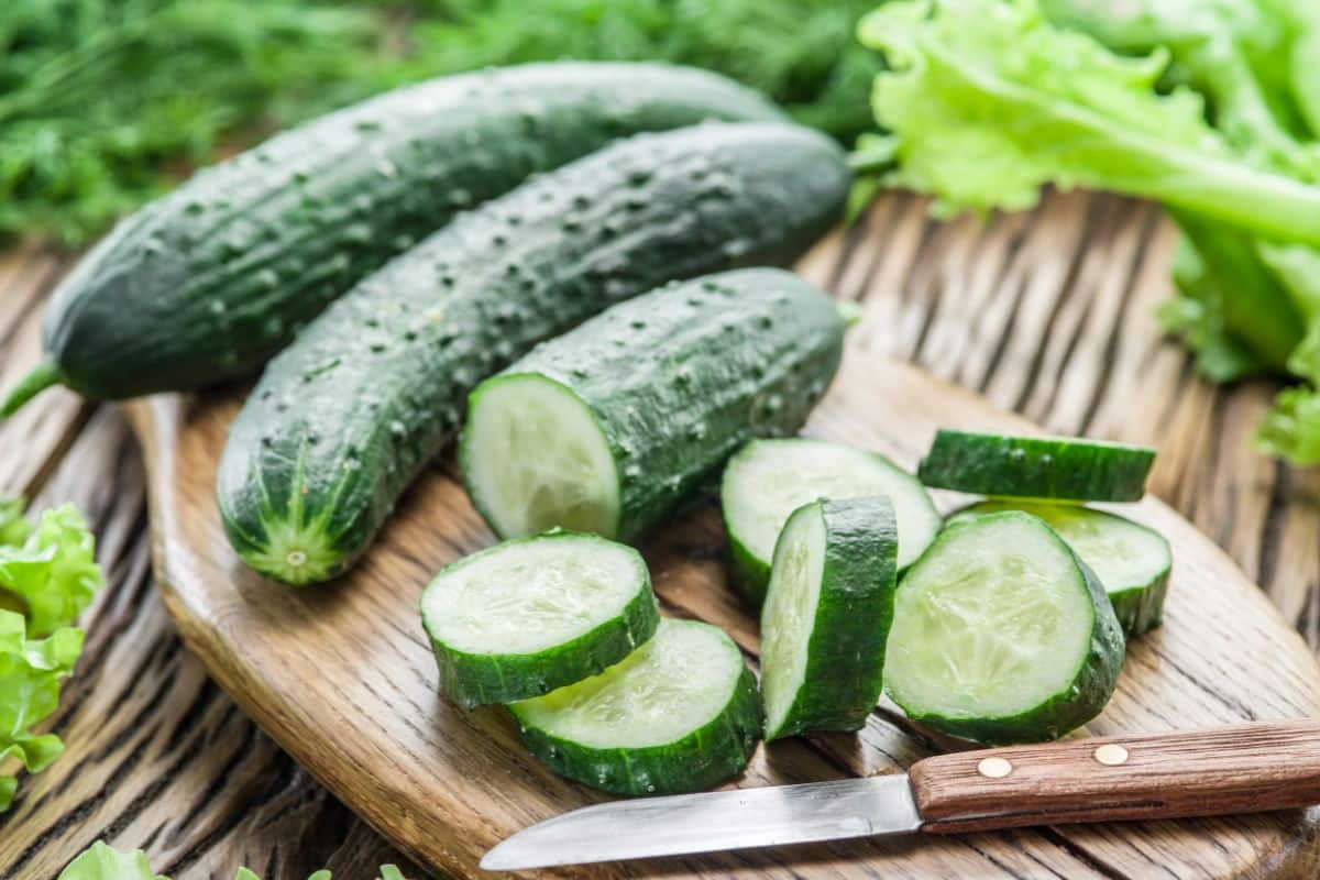 Cucumbers as a substitute for celery on a cutting board with a knife.