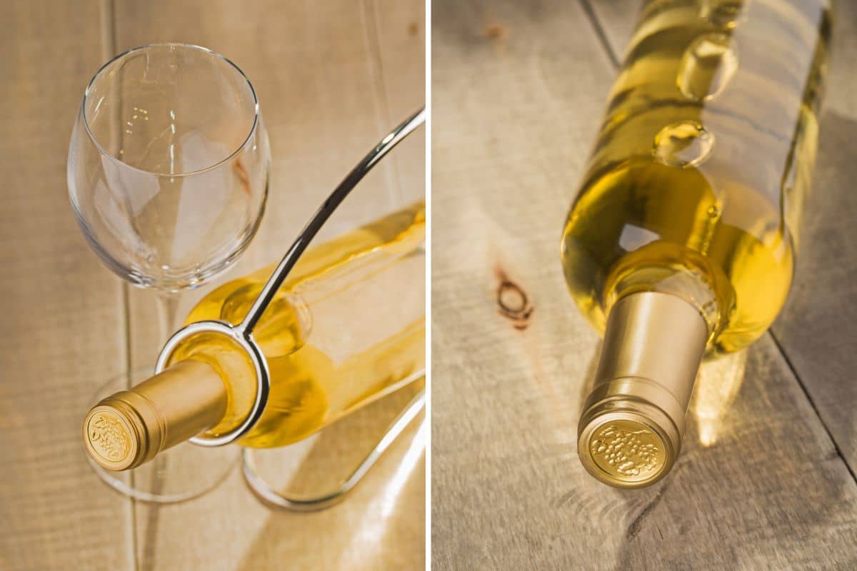 A bottle of dry white wine and a glass on a wooden table.