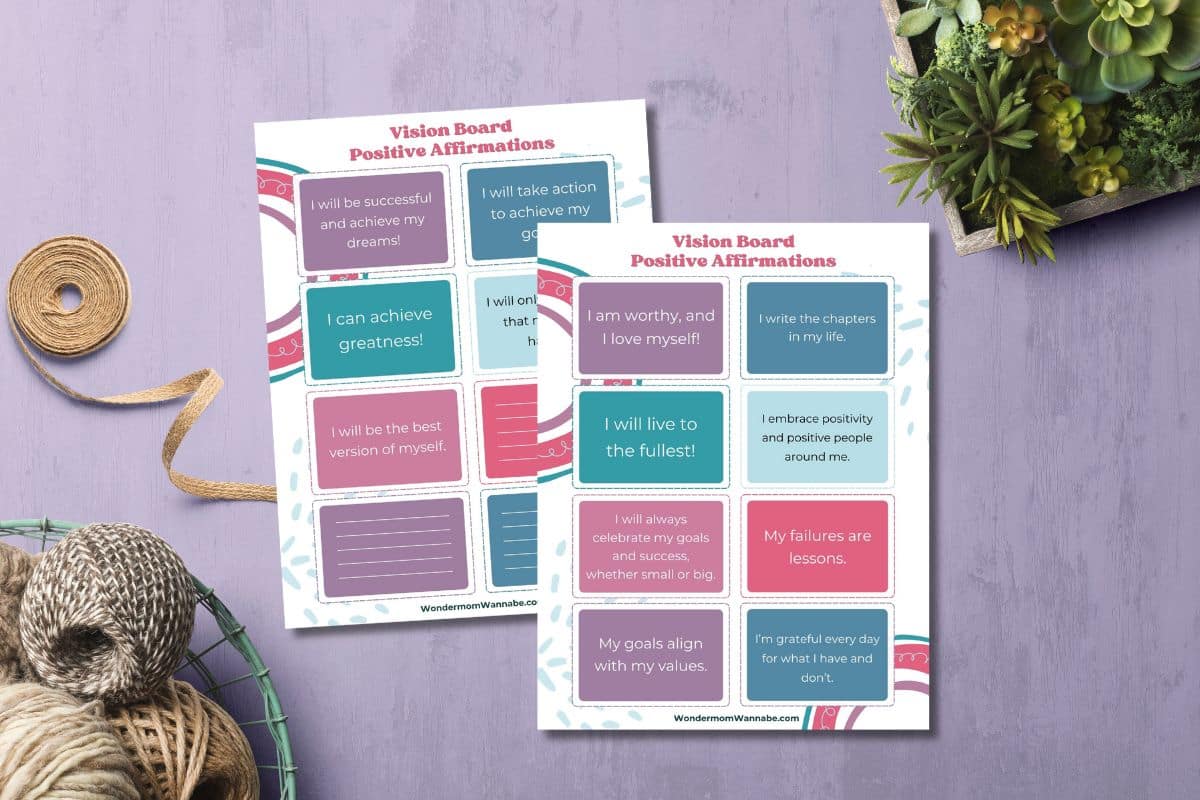 Vision board printables on a purple table with plants and jute strings on the side.