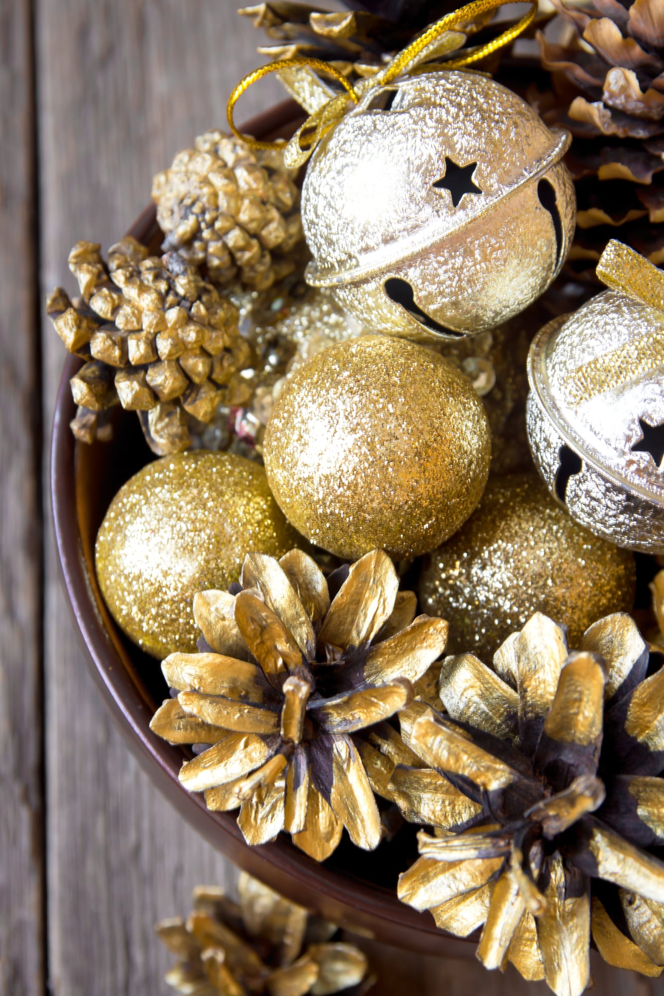 Christmas decorations in a bowl on a wooden table.