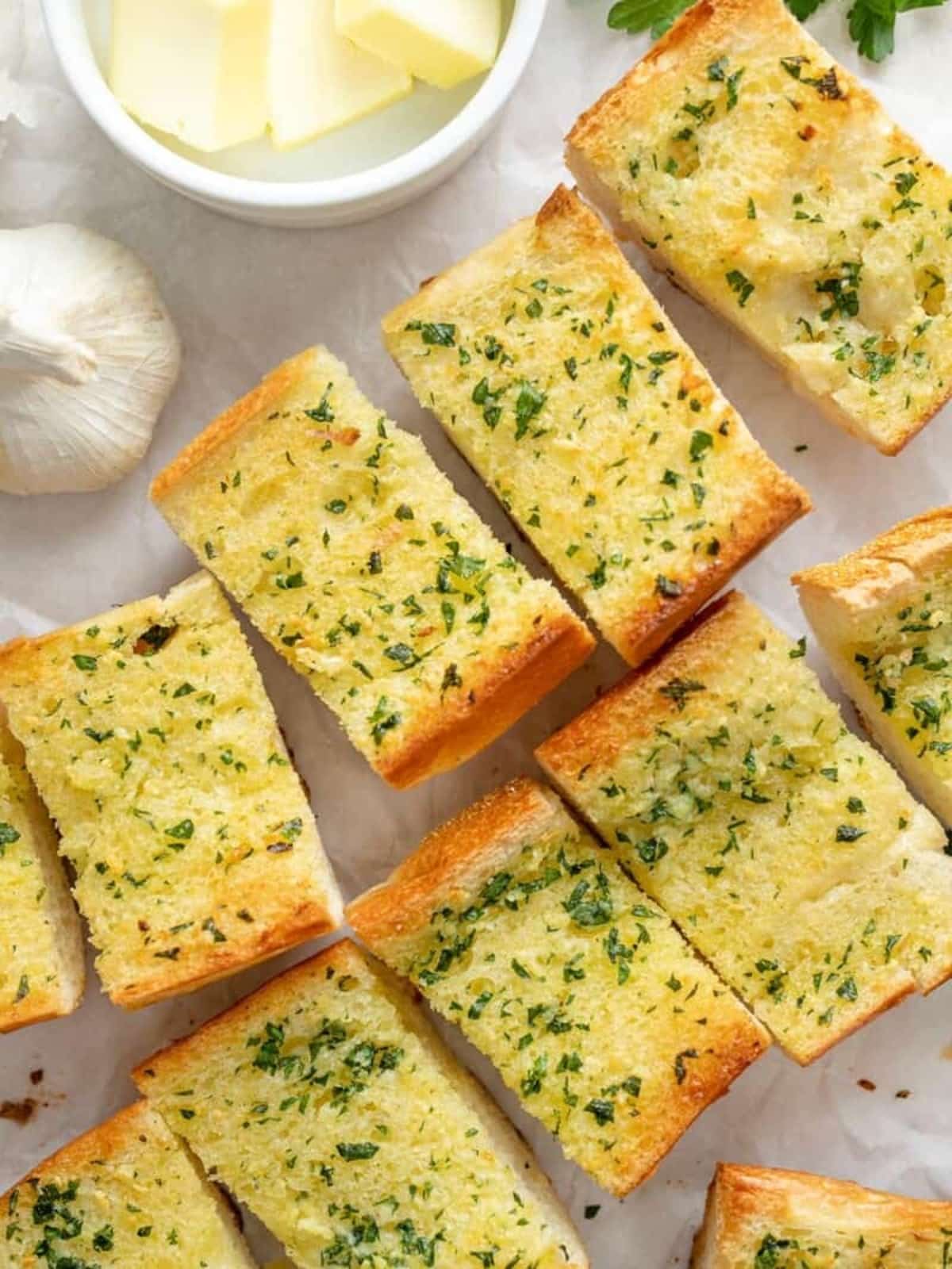 Sliced garlic bread with butter and parmesan cheese.