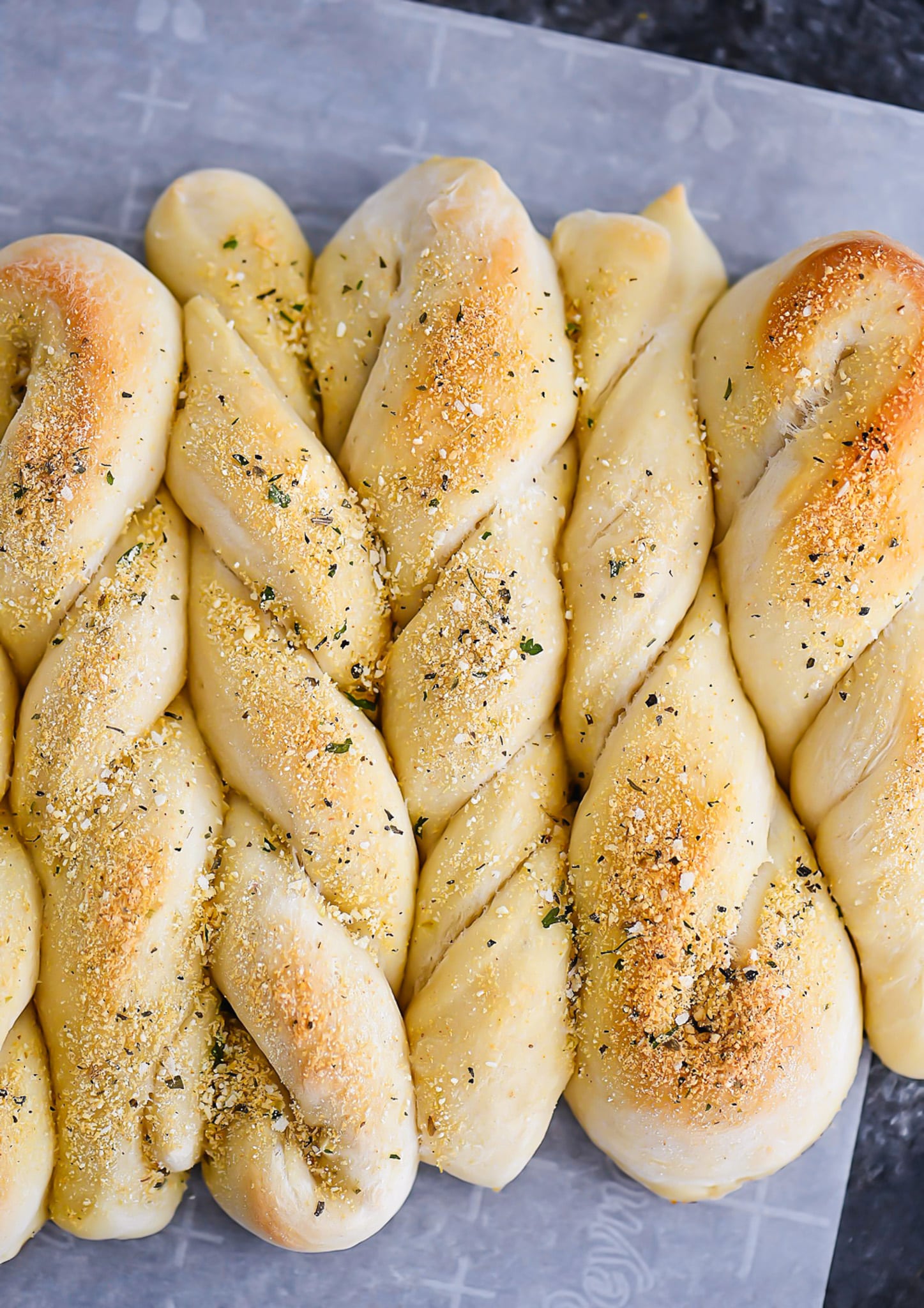 A baking sheet with a bunch of braided breads on it.