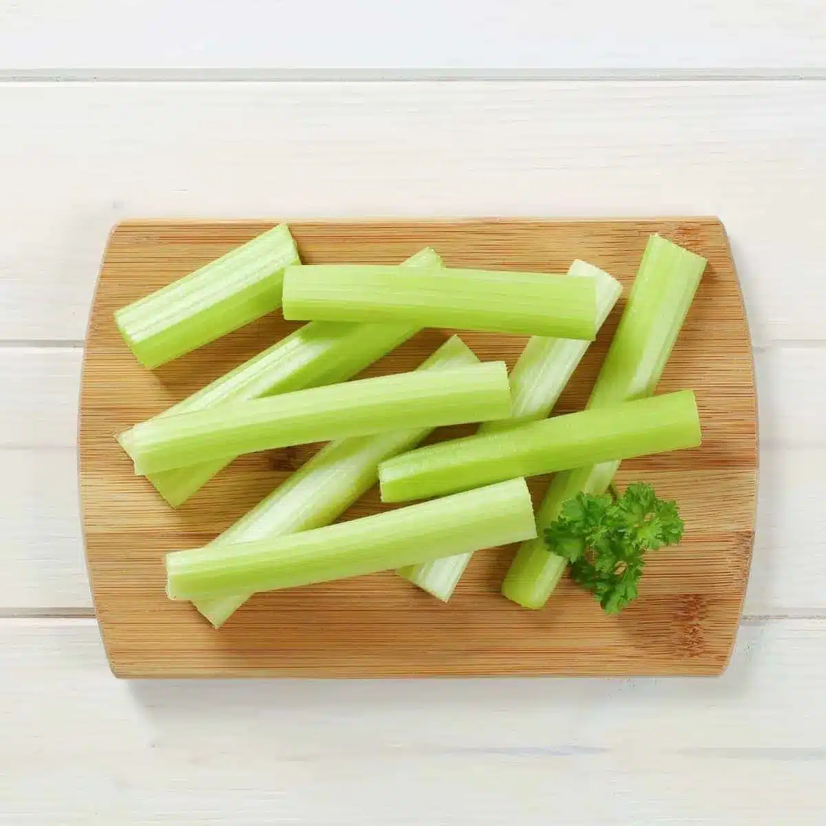 Celery sticks on a wooden cutting board.