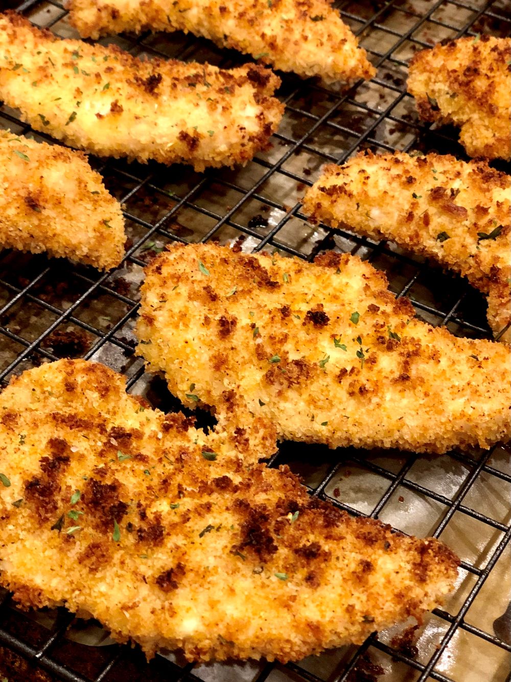 Fried chicken strips on a cooling rack.