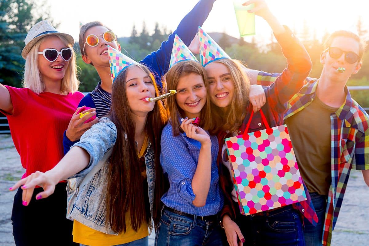 A group of friends celebrating a birthday party with fun and creative party theme ideas for teens.