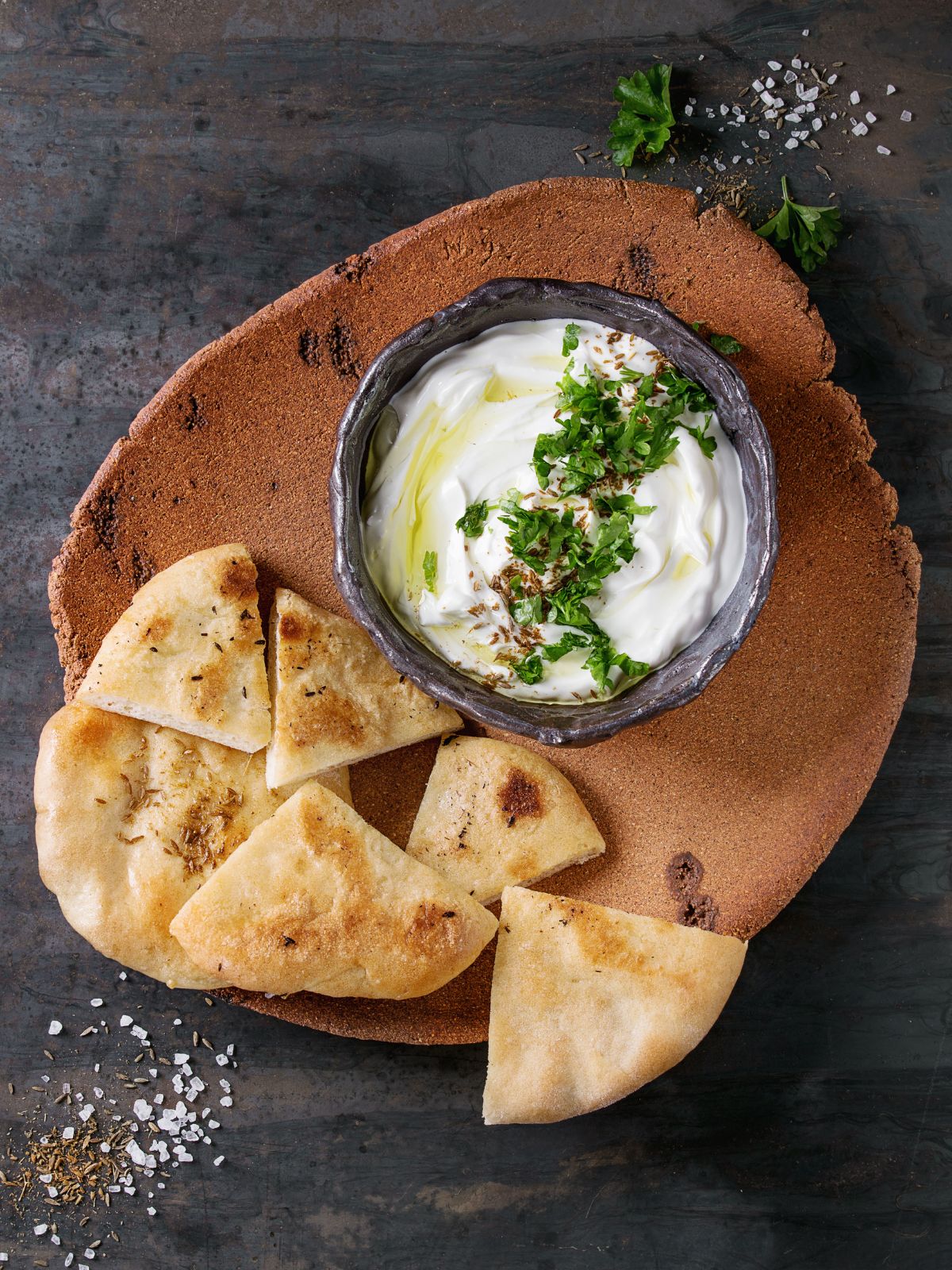 A plate with pita bread and a bowl of  lebanese cream cheese dip.