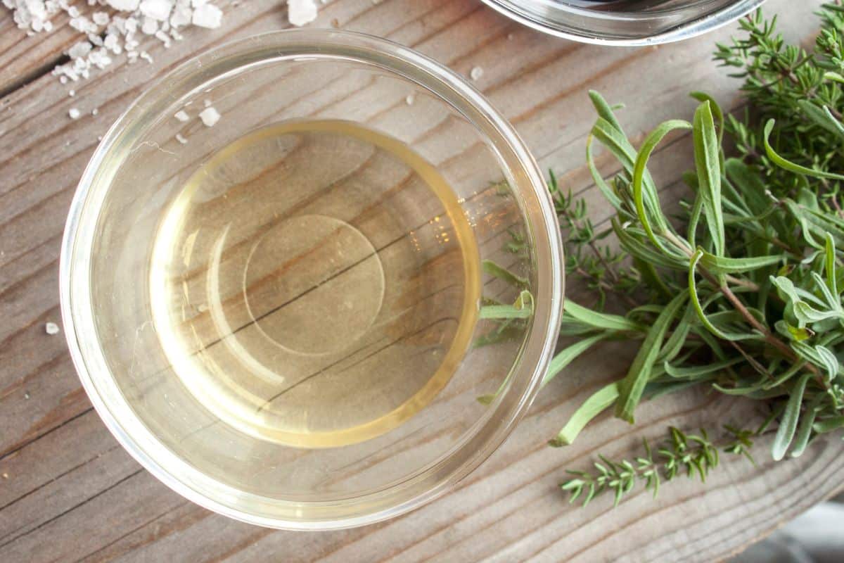 A bowl of White Wine Vinegar, an alternative for sherry vinegar, on a wooden table.