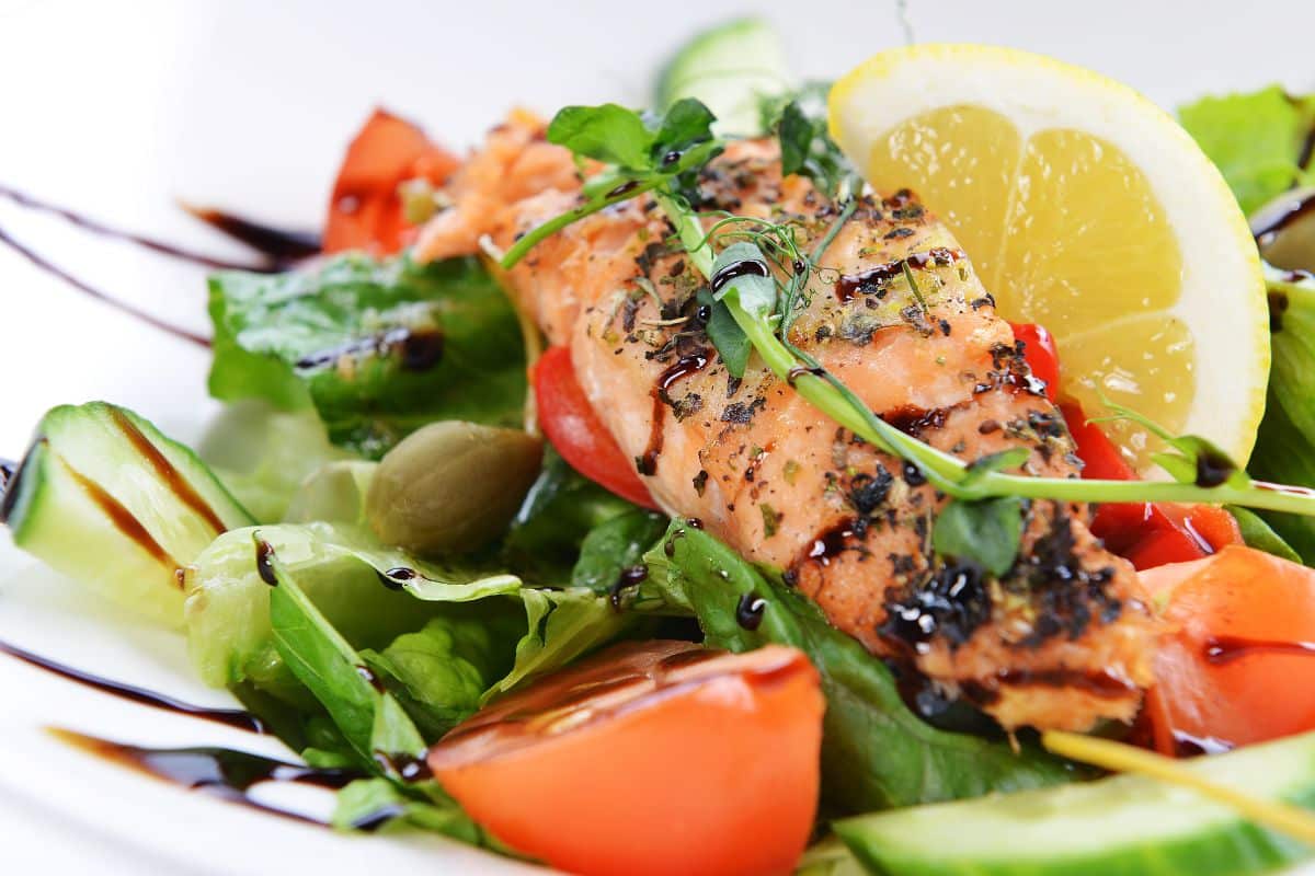 A plate with a salad and salmon drizzled with balsamic vinegar, an alternative for sherry vinegar.