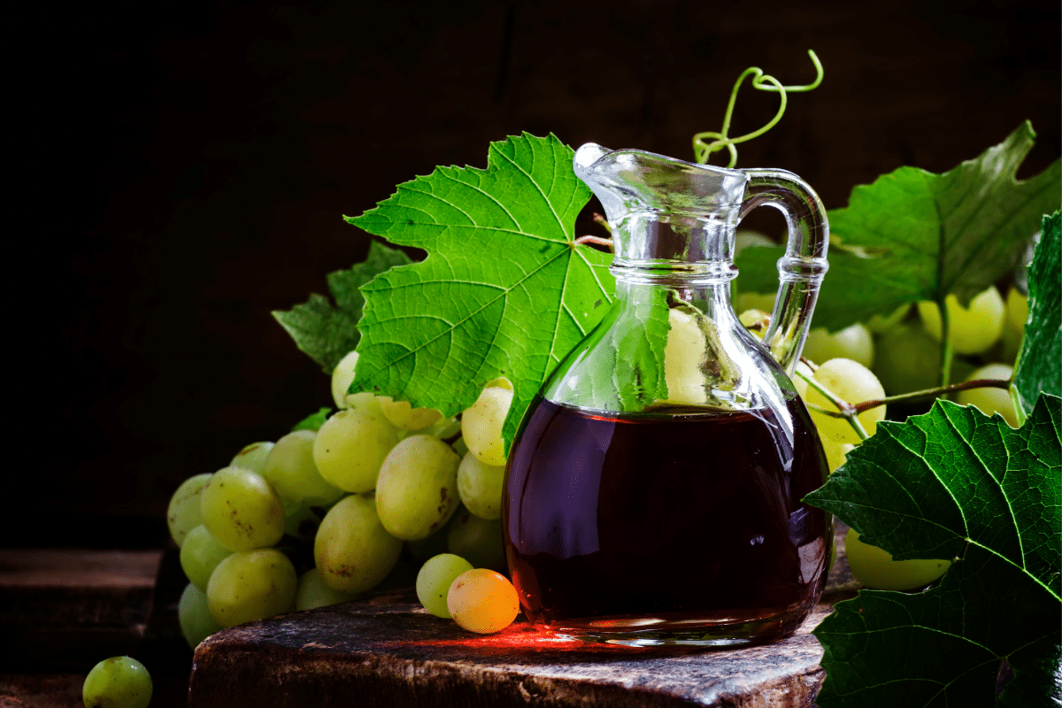 Sherry vinegar and grapes on a wooden table.