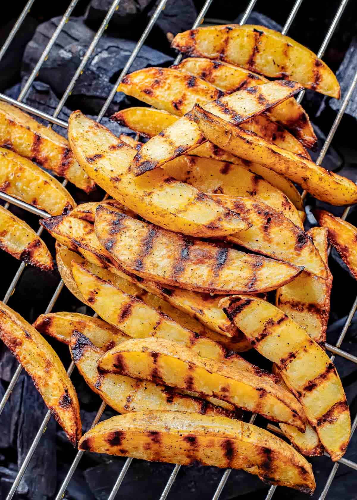 Grilled potato wedges on a grill.