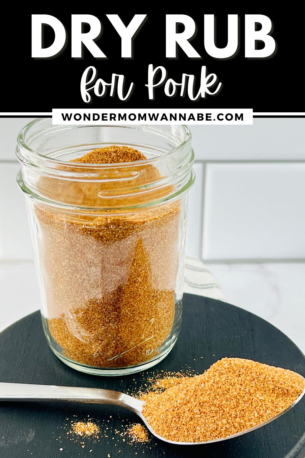 A jar of dry rub with a spoon next to it, perfect for pork.