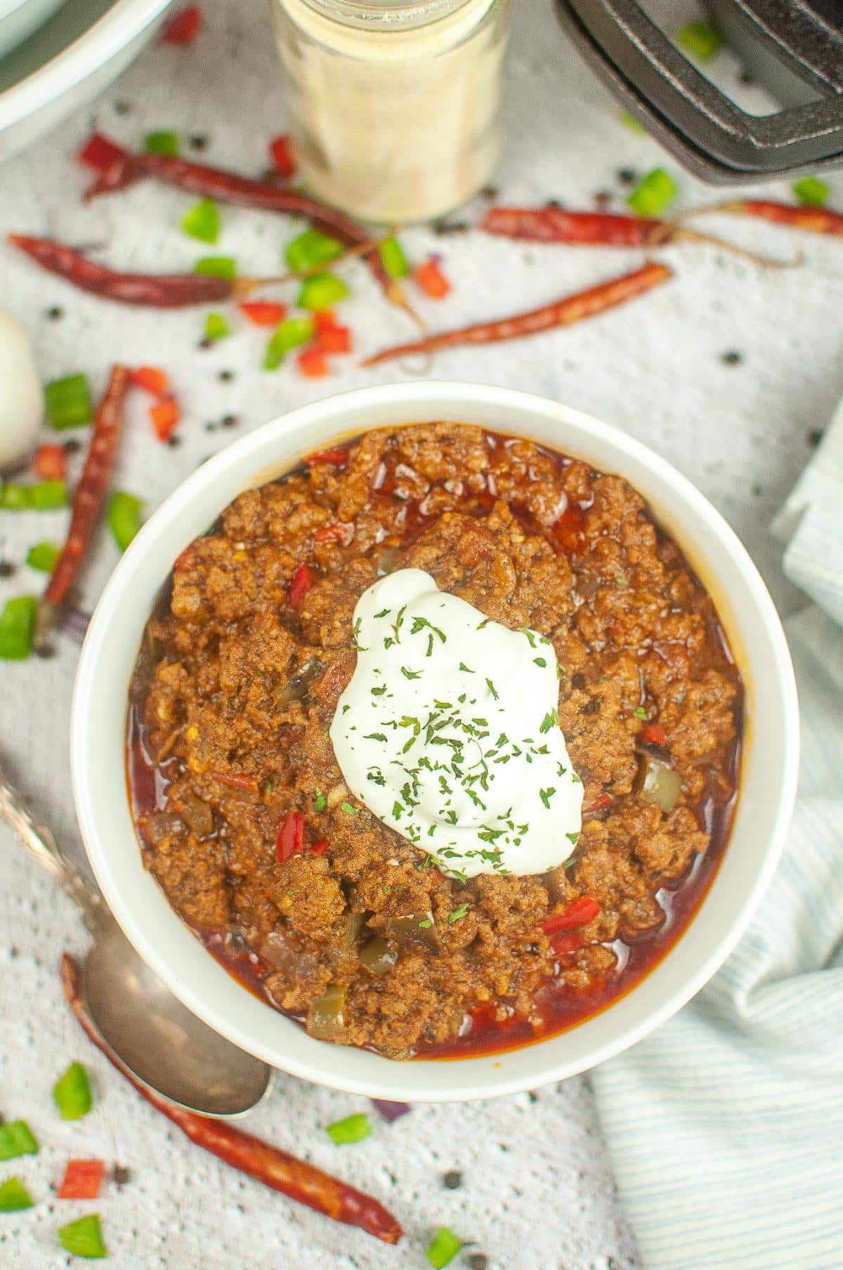 Dutch oven chili in a serving bowl, topped with a dollop of sour cream.