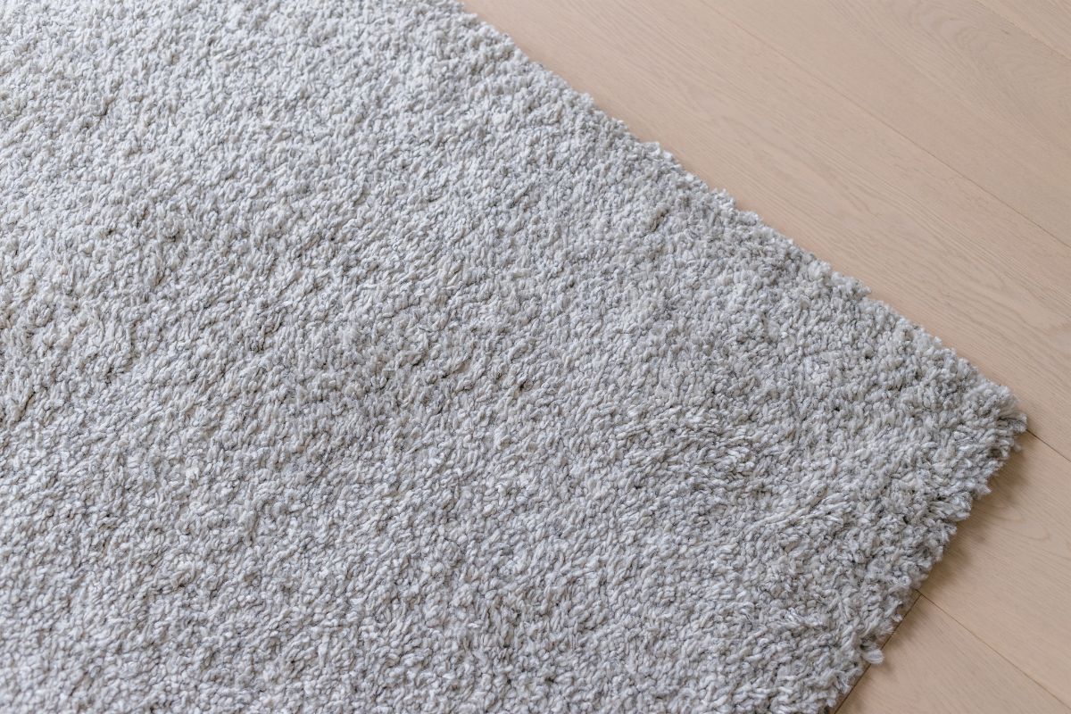 A gray carpet on a wooden floor.