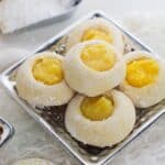 A tray of powdered lemon curd cookies filled with lemon curd.