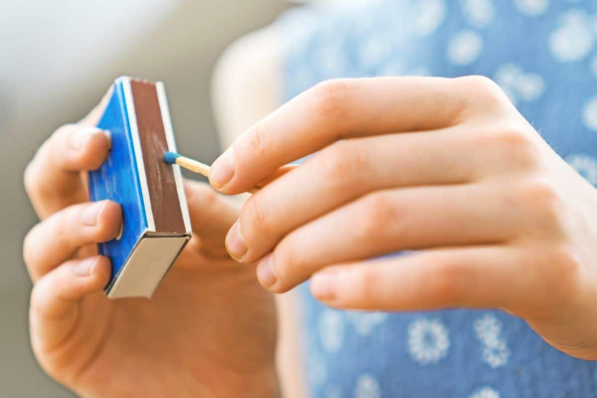 A kid holding a blue matchbox.