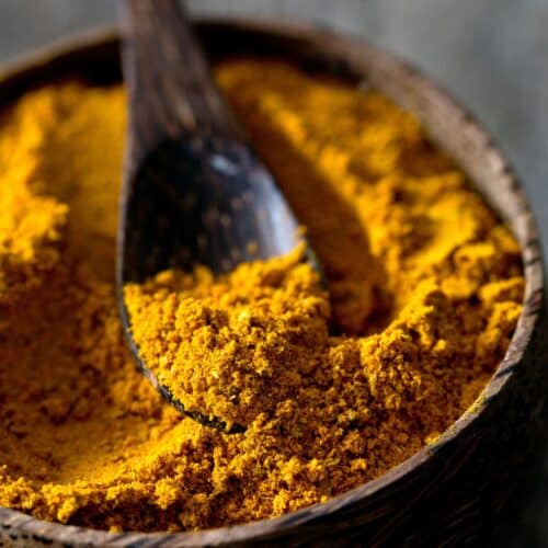 Tumeric powder in a wooden bowl, great substitute for curry powder.