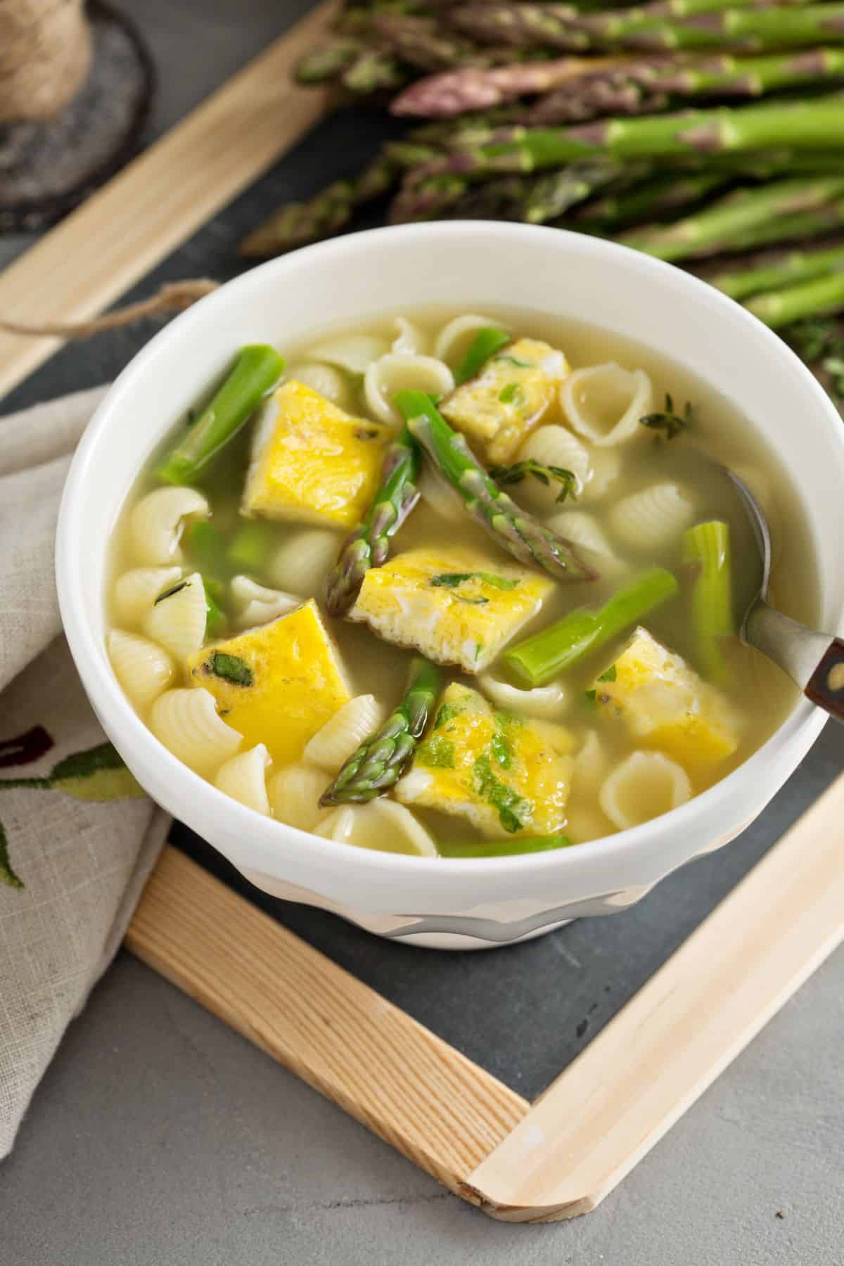 A bowl of soup with asparagus.