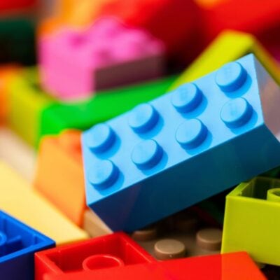 A close-up view of assorted colorful plastic building blocks, including a prominent blue block in the center.